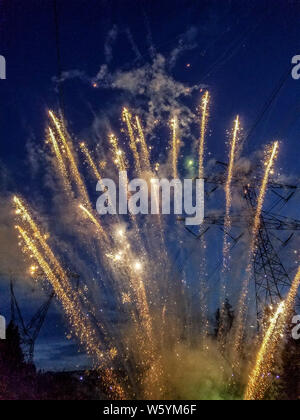 Nachbarschaft 4. Juli Feuerwerk in der Abenddämmerung im Westen des Bundesstaates Washington. Stromleitungen gesehen werden kann. Stockfoto