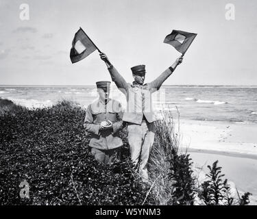 1910 s zwei UNIFORMIERTE MÄNNER IN UNITED STATES COAST GUARD SEMAPHORE SIGNALISIERUNG BUCHSTABEN J LONG BEACH ISLAND NEW JERSEY USA - c 99 HAR 001 HARS MÄNNER RISIKO SURF VERTRAUEN B&W STRAFVERFOLGUNG NORDAMERIKA NORDAMERIKA ERFOLG DISASTER ABENTEUER SCHUTZ STÄRKE MUT BEGEISTERUNG FÜHRUNG mächtig stolz auf Autorität berufen MATROSEN UNIFORMEN SIGNALISIERUNG KONZEPTIONELLE 1790 1848 DUNE ESCAPE LONG BEACH ISLAND STILVOLLE SUPPORT NEW JERSEY SCHIFFBRUCH UNIFORMIERTEN REGIERUNGSBEHÖRDE SEEMÄNNER SEMAPHORE GEBILDET LIFESAVING Mitte - Mitte - erwachsenen Mann MISSION PRÄZISION SEASHORE EINZIGARTIGE 1915 SCHWARZ UND WEISS Stockfoto