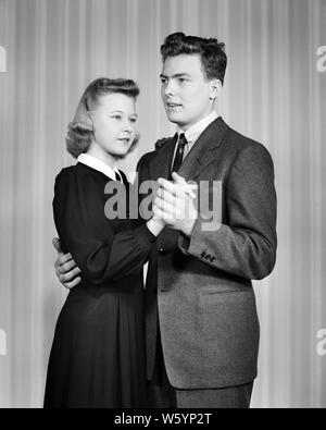 1950er unbeholfen MÜRRISCH GERADE - GESCHNÜRTE DOUR MAUERBLÜMCHEN PAAR, MANN UND FRAU NICHT GENIESSEN LANGSAM tanzen zusammen-d 1596 HAR 001 HARS BALANCE COMIC ABSTRAKTE LIFESTYLE FRAUEN IM STUDIO SHOT KOPIE RAUM IN VOLLER LÄNGE mit halber Länge DAMEN PERSONEN MÄNNER VERTRAUEN AUSDRÜCKE B&W TRAURIGKEIT UNGLÜCKLICHE DATING BIZARRE DISASTER komischen und grotesken FORTSCHRITTE ERHOLUNG ZANY UNKONVENTIONELLE ATTRAKTION UMWERBUNG KONZEPTIONELLE UNBEHOLFEN ESCAPE WACKY IDIOSYNKRATISCHE MÖGLICHKEIT GERADE - GESCHNÜRTE AMÜSANT EXZENTRISCHE WACHSTUM Mitte - Mitte - erwachsenen Mann langsam soziale Aktivität SAUER ZWEISAMKEIT MAUERBLÜMCHEN junger Erwachsener FRAU SCHWARZ UND WEISS Stockfoto
