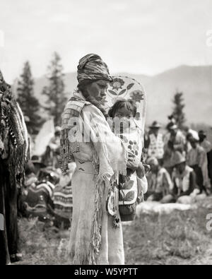 1920er Jahre 1930er Jahre NATIVE AMERICAN STONEY SIOUX INDIANISCHE FRAU MUTTER IN PERLEN HIRSCHLEDER KLEID HOLDING BABY JUNGE MÄDCHEN IN PAPOOSE KANADA - ich 59 HAR 001 HARS FRAUEN IM LÄNDLICHEN LEBEN ZU HAUSE KOPIEREN RAUM IN VOLLER LÄNGE mit halber Länge DAMEN PERSONEN TRADITIONELLE INDER B&W NORDAMERIKA NORDAMERIKA HIRSCHLEDER RÜCKANSICHT IN KONZEPTIONELLEN PAPOOSE NATIVE AMERICAN BABY BOY STONEY SIOUX RÜCKANSICHT HIRSCHLEDER GESÄUMTEN jugendliche Mitte nach Mitte der erwachsenen Frau Mammen gebürtige Amerikaner BABY GIRL PERLEN schwarzes und weißes Kind TRÄGER CRADLE BOARD HAR 001 INDIGENEN ALTMODISCH Stockfoto