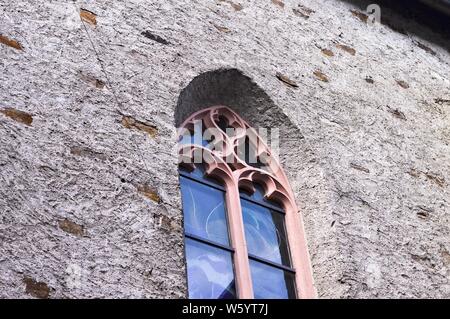 Rosa gotischen Fenster mit Fensterkreuz - Mauer Hintergrund (Deutschland, Europa) Stockfoto