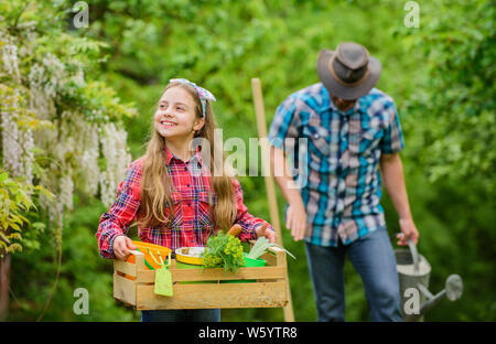 Pflanzen gute Pflege benötigen. Kleines Mädchen und glücklicher Mensch Vati. Tag der Erde. Farm der Familie. Feder Dorf Land. Vater und Tochter auf Ranch. Ökologie. Gartengeräte. Schönheit im Garten arbeiten. Stockfoto