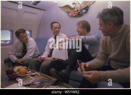 Zbigniew Brzezinski, Michael Blumenthal, Jimmy Carter und Cyrus Vance an Bord der Air Force One während einer Reise nach London für die G7-Wirtschaftsgipfel Stockfoto