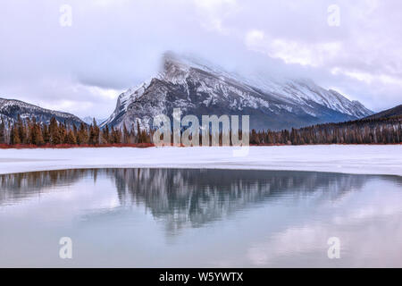 Kalten Wintermorgen mit niedrigen Wolken auf dem Mount Rundle Vermilion aus Seen in der kanadischen Rockies Banff National Park wider. Stockfoto