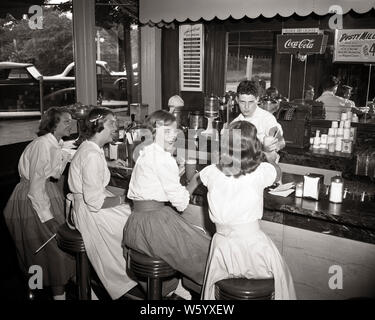 1950 VIER JUNGE MÄDCHEN SITZT UND SERVIERT ICE CREAM SODA AM ZÄHLER VON SUBURBAN DRUG STORE von BOY SODA JERK BRONXVILLE NY USA-q 50276 CPC 001 HARS ALTE ZEIT BESETZT NOSTALGIE OLD FASHION 1 JUGENDLICHEN STIL KOMMUNIKATION BALANCE WETTBEWERB SÜSSE FREUDE FREUDE LIFESTYLE FRAUEN JOBS KOPIEREN RAUM MIT HALBER LÄNGE PERSONEN INSPIRATION FÜRSORGLICHE MÄNNER RISIKO PUBERTIERENDE TEENAGER VERTRAUEN MEDIKAMENT B&W SKILL BERUF GLÜCK FÄHIGKEITEN FRÖHLICHE KUNDEN SERVICE KNOWLEDGE SODA BERUFE SERVIERT LÄCHELT SODA JERK VERBINDUNG KONZEPTIONELLER ESCAPE FREUDIGE TEENAGED EIS NACH DER SCHULE Wachstum von Jungfischen ENTSPANNUNG Stockfoto