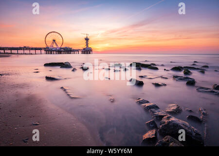 Sonnenuntergang an der Küste, Strand, Pier und Riesenrad, Scheveningen, Den Haag. Stockfoto