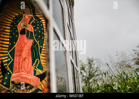 Kapelle mit religiösen Bildern. Wandbild mit dem Bild der Jungfrau marita, Jungfrau von Guadalupe in der Mitte der Landschaft, Sonora, Mexiko. Capilla con Imagenes religiosas. Wandbild con la Imagen de la Virgen, Marita, Virgen de Guadalupe en el Medio del paisaje Stockfoto