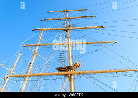 Ansicht von unten auf den Mast, Segel Yards mit der abgesenkten Segel und Takelage eines Segelschiffes gegen einen klaren Himmel an einem sonnigen Tag. Stockfoto