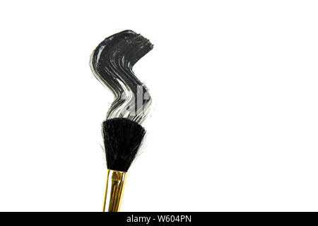 Flach auf Black Charcoal Schlamm Maske mit Make-up-Pinsel auf weißem Hintergrund verwenden Für isolierte verschmiert. Gesichtspflege. Stockfoto