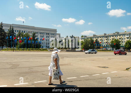 Lugansk, Ukraine - Jule 3, 2019: Melden Sie sich an Ich Lugansk auf dem Theaterplatz in der Nähe von Lenin Denkmal der Liebe. Ältere Frau die Straße zu überqueren. Lugansk, Ukraine Stockfoto