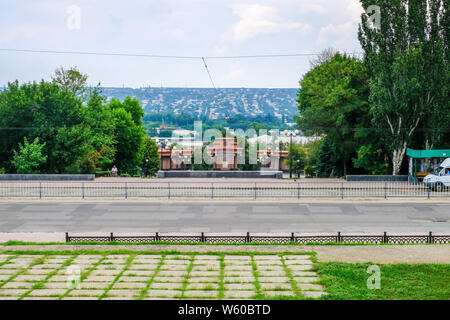 Lugansk, Ukraine - Jule 24, 2018: Denkmal für die Kämpfer der Revolution auf dem Hintergrund der alten Stadt. Lugansk, Ukraine Stockfoto