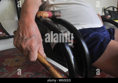 Andarias Sarra, 80, hält seinen Spazierstock, während im Haus Veranda in Kapasa Dorf sitzen. Herr Sarra überlebt von zwei Anschlag Angriffe. Er ersten Stockfoto