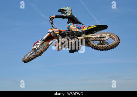 Motorradfahrer auf jagt Bike, springen hoch in den blauen Himmel. Motocross ist eine Form von Motorradrennen auf rauhen Off-road-Rennstrecken statt. Dirt Bike mx Stockfoto