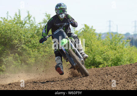 Motorradfahrer auf jagt Bike Racing auf schlammigen Rennstrecke. Motocross ist eine Form von Motorradrennen auf rauhen Weg beigelegt - Straße Kreise statt. Stockfoto