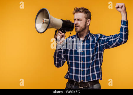 Wütend Demonstrant Mann mit Megaphon auf gelbem Hintergrund-Bild Stockfoto