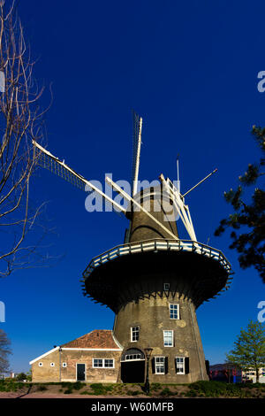 Leiden, Holland, Niederlande, 21. April 2019. Street View, Molen De Valk Museum (Falcon Windmühle) traditionelle Häuser abgestellte Fahrräder und Radfahrer Stockfoto