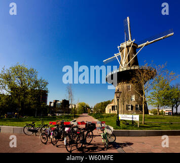 Leiden, Holland, Niederlande, 21. April 2019. Street View, Molen De Valk Museum (Falcon Windmühle) traditionelle Häuser abgestellte Fahrräder und Radfahrer Stockfoto