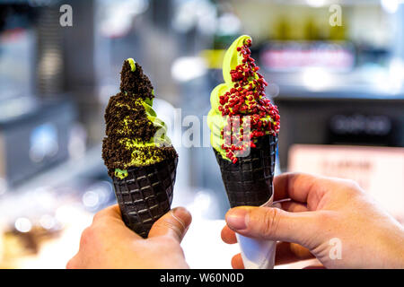 Matcha Softeis in schwarzen Kegel mit toppings in Halle, London, UK Stockfoto