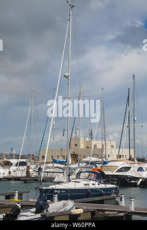 Sammlung von privaten Boote/Yachten vor der cremefarbenen Service Gebäude an der Hafen von Jachthafen von Cascais Cascais, Portugal. Stockfoto