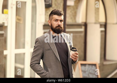 Geschäftsmann gepflegt aussehen genießen Sie Kaffee Pause aus Business Center. Entspannen und erholen Sie sich. Man bärtige hipster Pappbecher Kaffee trinken. Noch ein Schluck Kaffee. Kaffeegenuss unterwegs. Stockfoto