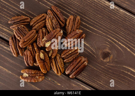 Menge ganz ohne Schale frische braune Pekannuss Hälfte flatlay auf braunem Holz Stockfoto