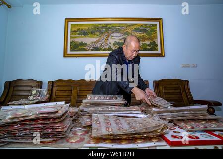 Chinesische älterer Mann Huang Junde zeigt Abzeichen des Porträts von verstorbenen Vorsitzenden Mao Zedong, die er in den vergangenen 50 Jahren in seinem Haus in Chong gesammelt Stockfoto