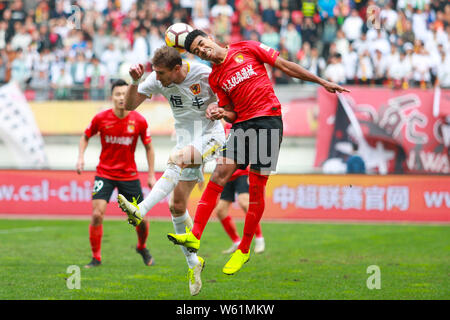 Kroatischer Fußballspieler Nikica Jelavic, links, von Guizhou Hengfeng Köpfe die Kugel gegen den brasilianischen Fußballspieler Alan Carvalho von Guangzhou Evergra Stockfoto