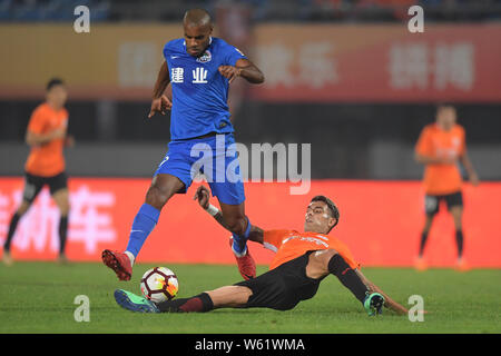 Portugiesische Fußball-Spieler Ricardo Vaz Te von Henan Jianye, obere, dribbelt gegen die argentinische Fußball-Spieler Augusto Fernandez von Peking Renhe in der Stockfoto