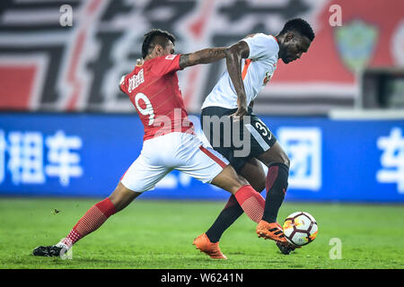 Brasilianische Fußballspieler Paulinho, links, von Guangzhou Evergrande Taobao Herausforderungen senegalesischer Fußballspieler Makhete Diop von Peking Renhe in Ihrer Stockfoto