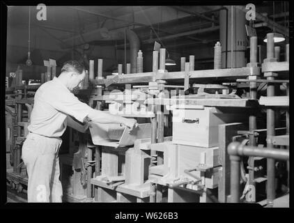 Camden, New Jersey -. RCA Victor. Kabinett Assembler-Montage Taille (vorn und an den Enden der Schaltschrank). Diese Assembler setzt auch zwei wichtige Schienen einrasten. Er ist gelernter Schreiner. Obwohl die Arbeit nicht zu Skill, nur ein Mann, der eine gründliche Kenntnis der Cabinet -, kann dieser Teil der Montage Job richtig machen müssen. Die förderanlage benötigt 20 Minuten, um eine vollständige Umdrehung zu machen. Stockfoto