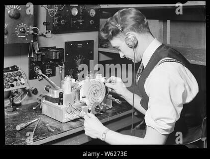 Camden, New Jersey - Radio. RCA Victor. Letzte Inspektor - Testen radio frequency Ausrichtung und der letzte Test der Chassis. Dies erfolgt in einem Zimmer vollständig von Kupfer Abschirmung umgeben, um die Prüfung von Störungen zu schützen. Das ist der Job, der höchste Skill. Auch technische Schulungen, wie z.b. der Elektrotechnik Kurs muss durch eine Ausbildung im Werk für diese Arbeit ergänzt werden. Stockfoto