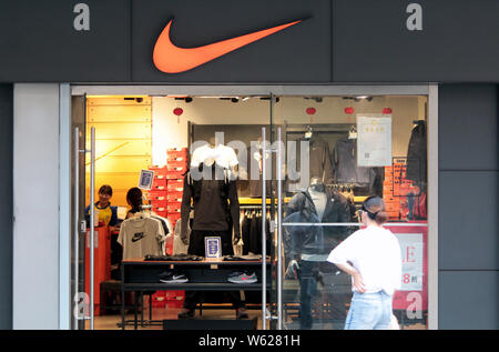 ---- Ein Fußgänger geht hinter einem Nike Store in Shanghai, China, 26. September 2018. Sportswear riesen Nike Inc's neu Erste globale Flaggschiff s geöffnet Stockfoto