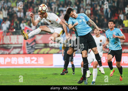 Kroatischer Fußballspieler Nikica Jelavic, links, von Guizhou Hengfeng leitet den Ball gegen Spieler von Dalian Yifang in der 26. Runde während des Th Stockfoto