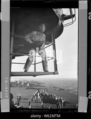 Kapitän Edward J.Steichen, USNR, (im Ruhestand), Photographic Expert, auf der Insel Plattform, Studien seiner Umgebung für eine seiner herausragenden Fotografien des Lebens an Bord eines Flugzeugträgers. Kapitän Steichen hielt den Rang eines Comdr..; Allgemeine Hinweise: Verwenden Sie Krieg und Konflikt Nummer 759 bei der Bestellung eine Reproduktion oder Anforderung von Informationen zu diesem Bild. Stockfoto