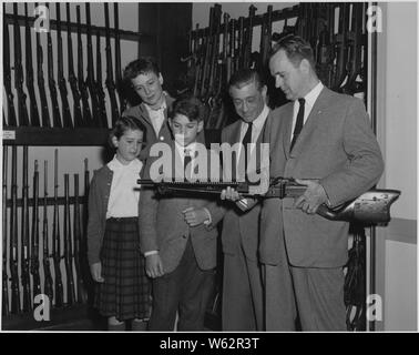 Carl Mydans, der auf der fotografischen Mitarbeiter der Zeitschrift Life, besuchte FBI HAUPTQUARTIER mit seiner Familie und wurde auf einer Tour von Special Agent Donald G. Hanning durchgeführt. Herr Mydans, seine Frau und Special Agent Hanning Kriegsgefangene der Japaner auf den Philippinen und in erneuerten ihre Bekanntschaft und gesehen ein Japanisches Maschinengewehr in der Feuerwaffen Abschnitt des FBI-Labor. Dargestellt sind von links nach rechts: Misty Mydans, Frau Mydans, Seth Mydans, Herr Mydans, und Special Agent Hanning. Stockfoto