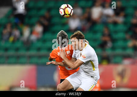 Kroatischer Fußballspieler Nikica Jelavic, rechts, von Guizhou Hengfeng Herausforderungen argentinischen Fußballspieler Augusto Fernandez von Peking Renhe in Ihrer 2. Stockfoto