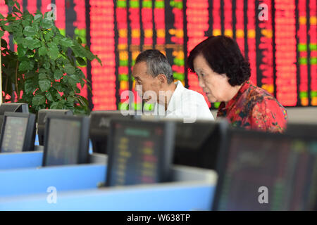 Chinesische Investoren sehen Sie sich die Preise von Aktien (rot für Preis steigt und grün für den Preis fallen) auf einer Börse brokerage House in Fuyang Stadt im Osten Chinas Stockfoto