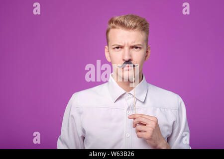 Lustig junge Mann mit Schnurrbart auf Hintergrund Stockfoto