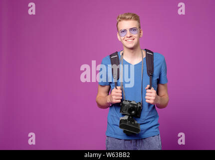 Mann Reisender mit der Kamera auf lila Hintergrund Stockfoto