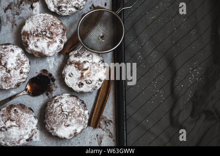 Die Muffins mit Puderzucker auf dem Backpapier. Stockfoto