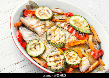 Gebackener Fisch mit Gemüse garnieren. Gebackenes Zanderfilet mit Zucchini und Paprika. Lecker gebackene ganze Fische Stockfoto