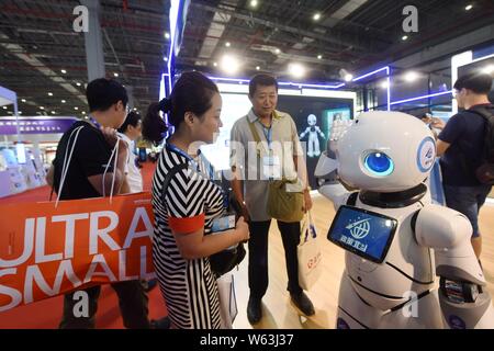 Chinesische Besucher sehen ein intelligenter Roboter auf dem Display während der 20. China International Industry Fair (CIIF 2018) in Shanghai, China, 19. September 2 Stockfoto