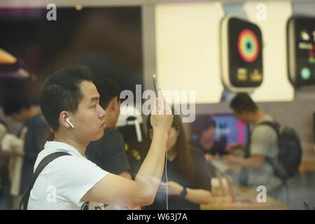 Ein chinesischer Kunde versucht, iPhone XS und XS Max Smartphones am West Lake Flaggschiff Apple Store in Hangzhou, Provinz Zhejiang, China Stockfoto