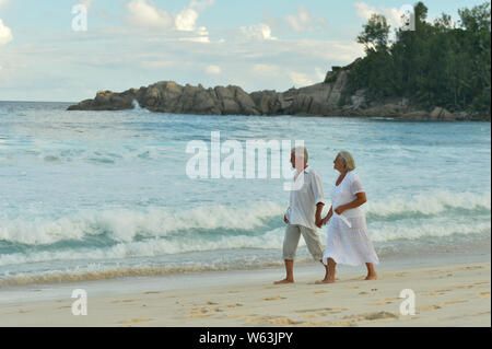 Porträt des älteren Paares zu Fuß auf tropischen Strand Stockfoto