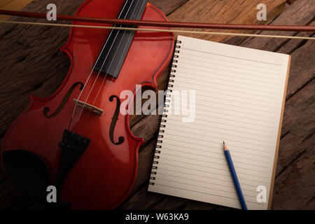 Nahaufnahme Violine Orchester Instrumental- und Notebook über Holz- Hintergrund wählen Sie Fokus flache Tiefenschärfe Stockfoto