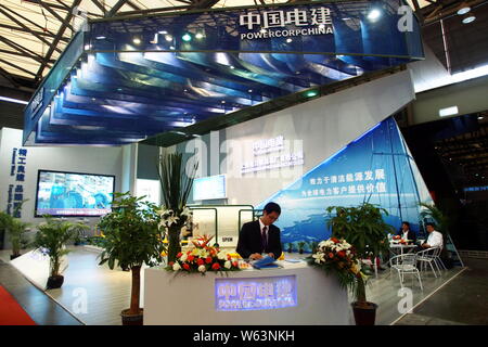 ---- Ein chinesischer Mitarbeiter ist auf dem Stand der Power Construction Corporation von China während der 2011 China International Industry Fair gesehen in Shangh Stockfoto