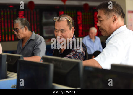 Chinesische Investoren sehen Sie sich die Preise von Aktien (rot für Preis steigt und grün für den Preis fallen) auf einer Börse brokerage House in Fuyang Stadt im Osten Chinas Stockfoto