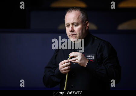 John Higgins von Schottland Kreiden seine Cue als hält er einen Schuß zu Ryan Tag von Wales in ihrer zweiten Runde während der 2018 Shanghai Masters snook Stockfoto