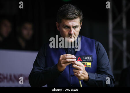 Ryan Tag der Wales Kreiden seine Cue als hält er einen Schuß zu John Higgins von Schottland in ihrer zweiten Runde während der 2018 Shanghai Masters snook Stockfoto