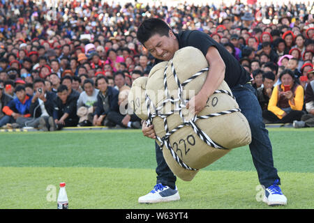 Ein Teilnehmer versucht, ein sandsack während eines starken Mannes Herausforderung in Markam County, Chamdo Stadt, im Südwesten Chinas Tibet autonomen Region, 4 Septem zu heben Stockfoto